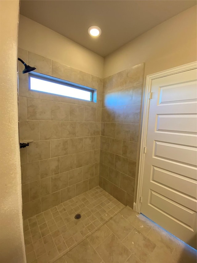 bathroom featuring tile patterned flooring and tiled shower