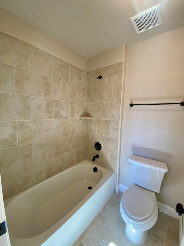 bathroom featuring toilet, tile patterned flooring, and tiled shower / bath combo