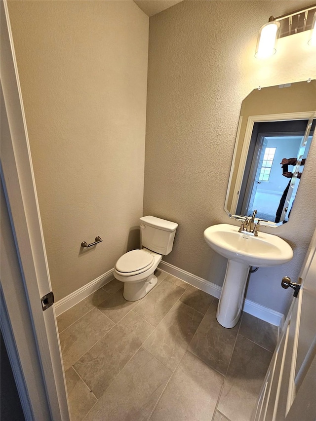 bathroom featuring tile patterned flooring and toilet