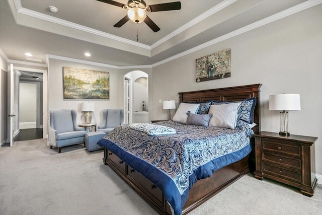 carpeted bedroom featuring a tray ceiling, ceiling fan, and crown molding