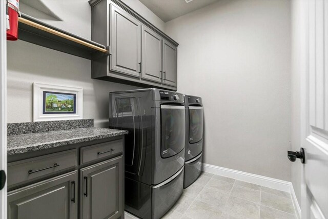 washroom with washer and dryer and cabinets