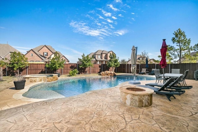 view of pool featuring pool water feature, a patio area, an in ground hot tub, and an outdoor fire pit