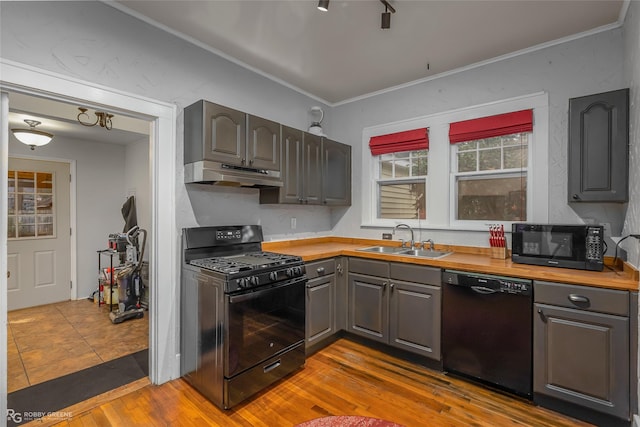 kitchen with gray cabinets, sink, ornamental molding, black appliances, and light hardwood / wood-style flooring