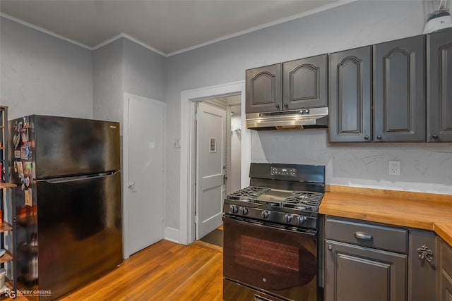 kitchen with crown molding, light hardwood / wood-style flooring, wooden counters, gray cabinetry, and black appliances