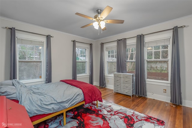 bedroom featuring multiple windows, hardwood / wood-style flooring, and crown molding