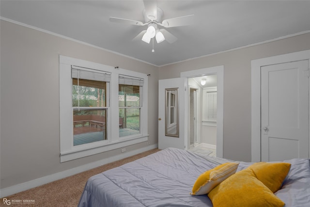 carpeted bedroom with crown molding, ensuite bath, and ceiling fan