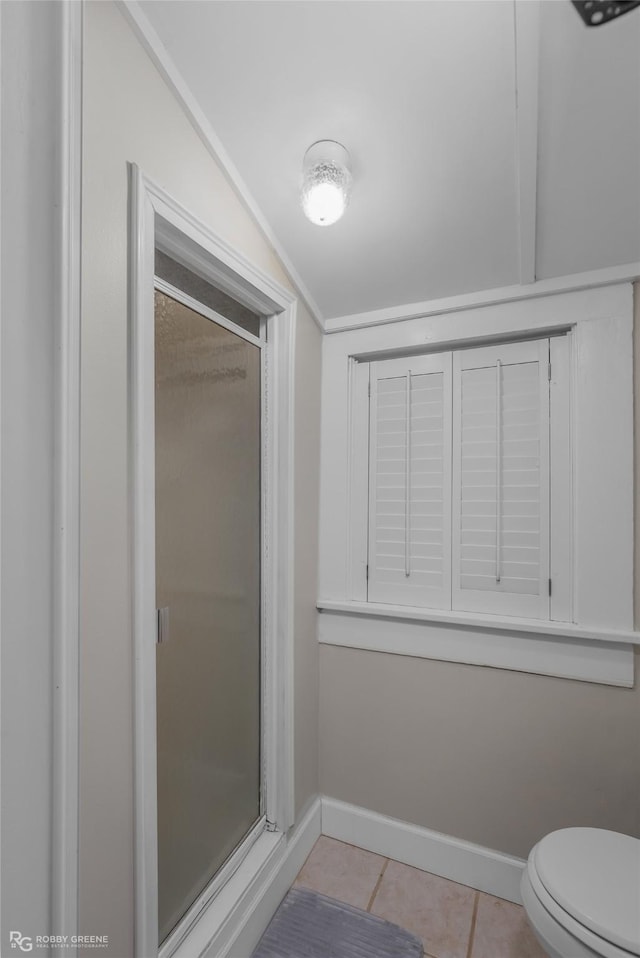 bathroom with lofted ceiling, tile patterned floors, and toilet