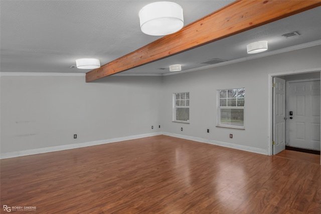 spare room with ornamental molding, hardwood / wood-style floors, and beam ceiling