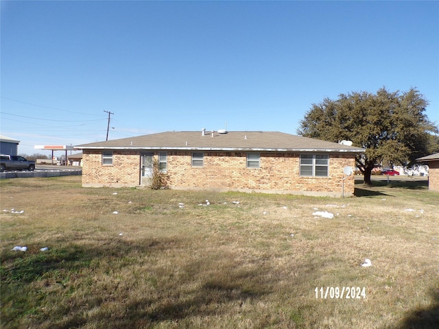 back of property featuring a yard