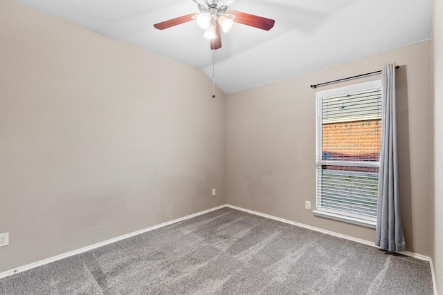 spare room with carpet flooring, vaulted ceiling, and ceiling fan