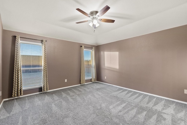 carpeted spare room with ceiling fan, plenty of natural light, and lofted ceiling