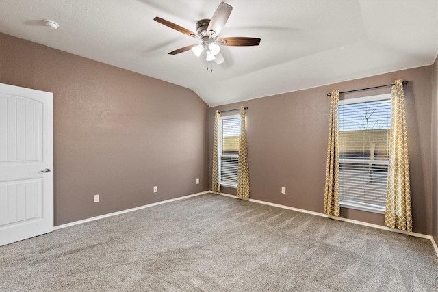 empty room featuring ceiling fan, plenty of natural light, carpet, and lofted ceiling