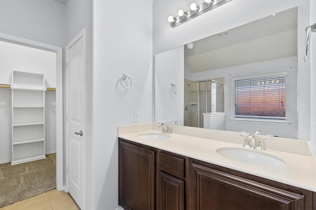 bathroom with tile patterned floors, vanity, and walk in shower