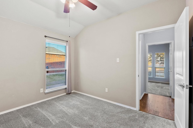 carpeted empty room featuring ceiling fan and lofted ceiling