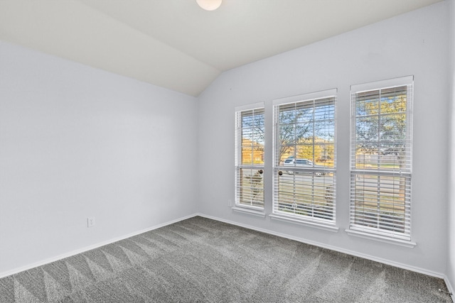 carpeted empty room with lofted ceiling