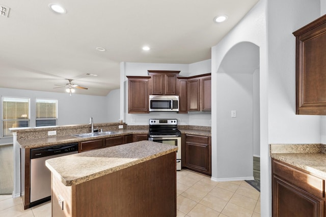 kitchen featuring ceiling fan, sink, stainless steel appliances, kitchen peninsula, and a kitchen island