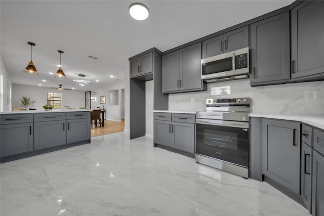 kitchen featuring gray cabinetry, backsplash, hanging light fixtures, and appliances with stainless steel finishes