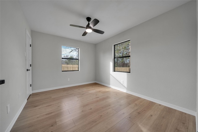 spare room with light hardwood / wood-style flooring, a wealth of natural light, and ceiling fan