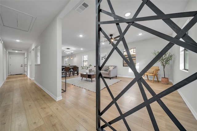 corridor with light hardwood / wood-style flooring and lofted ceiling