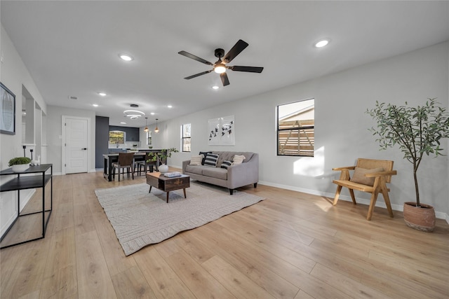 living room featuring ceiling fan and light wood-type flooring