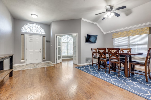 dining area with hardwood / wood-style floors, crown molding, vaulted ceiling, and ceiling fan