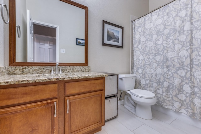 bathroom with vanity, tile patterned flooring, and toilet