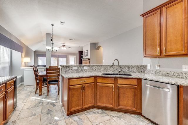 kitchen with pendant lighting, sink, dishwasher, light stone counters, and kitchen peninsula