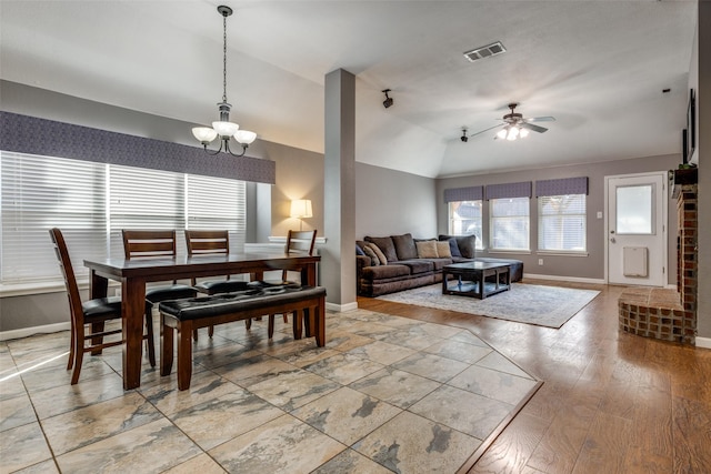 dining space with lofted ceiling, hardwood / wood-style floors, and ceiling fan with notable chandelier