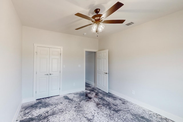 unfurnished bedroom with concrete floors, a closet, and ceiling fan