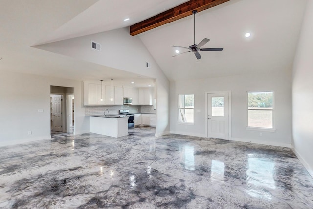 unfurnished living room with beam ceiling, ceiling fan, high vaulted ceiling, and a healthy amount of sunlight