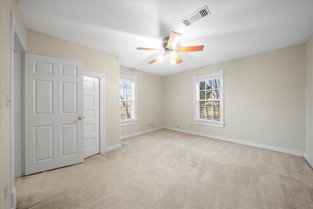 unfurnished bedroom with ceiling fan and light colored carpet