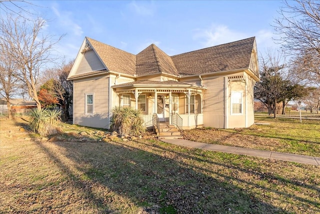 victorian house featuring a porch and a front lawn