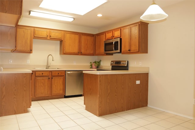 kitchen with kitchen peninsula, stainless steel appliances, sink, decorative light fixtures, and light tile patterned flooring