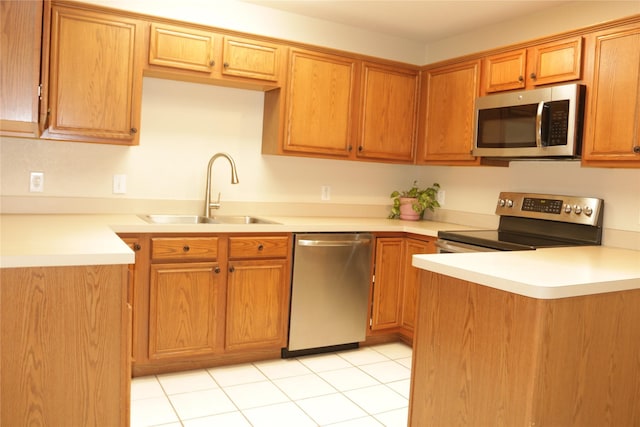 kitchen featuring light tile patterned floors, stainless steel appliances, and sink