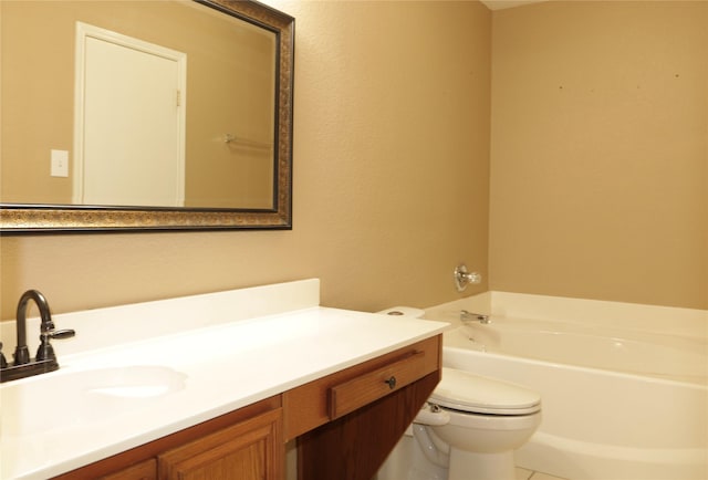 bathroom featuring vanity, a tub to relax in, and toilet