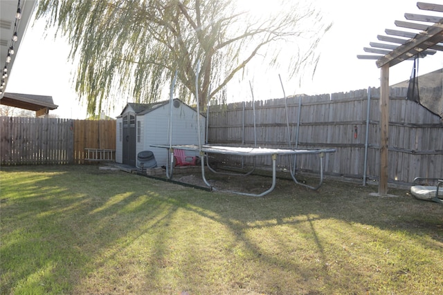 view of yard with a storage unit and a trampoline