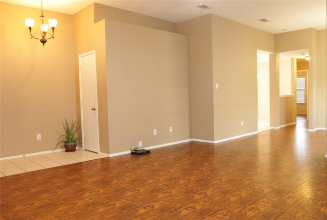 unfurnished room featuring light wood-type flooring and an inviting chandelier