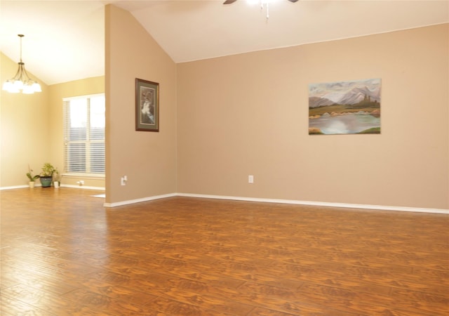 empty room featuring hardwood / wood-style flooring, ceiling fan with notable chandelier, and lofted ceiling