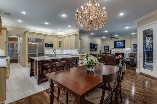 dining space featuring crown molding, ceiling fan, sink, and light wood-type flooring