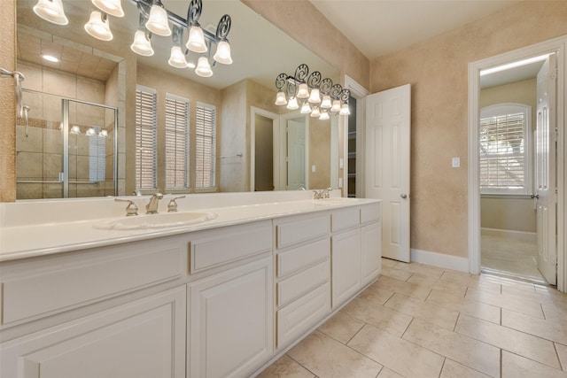 bathroom with tile patterned flooring, vanity, a shower with door, and an inviting chandelier