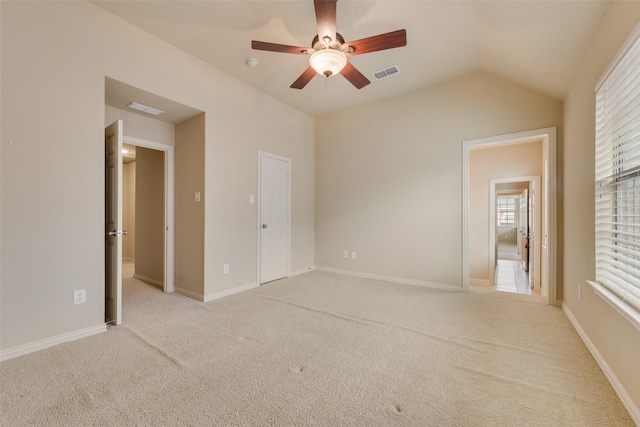 unfurnished bedroom with ceiling fan, a closet, light carpet, and vaulted ceiling