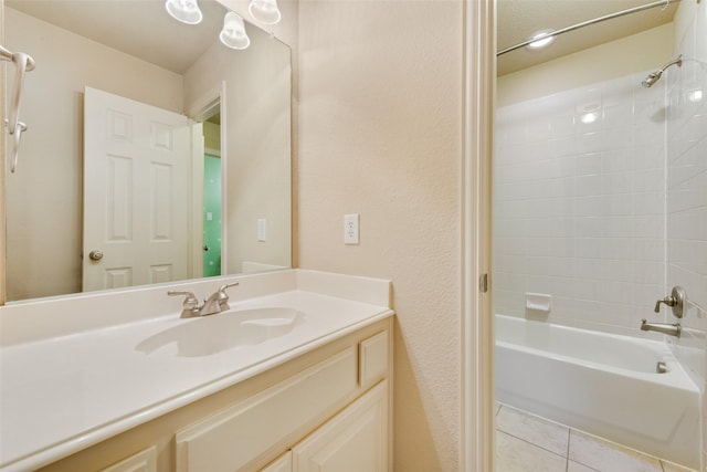 bathroom featuring tile patterned flooring, vanity, and tiled shower / bath