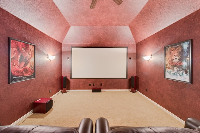 carpeted home theater featuring vaulted ceiling and ceiling fan