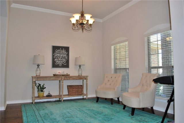 sitting room featuring hardwood / wood-style flooring, ornamental molding, and a chandelier