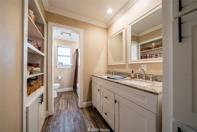 bathroom featuring toilet, vanity, crown molding, and hardwood / wood-style floors