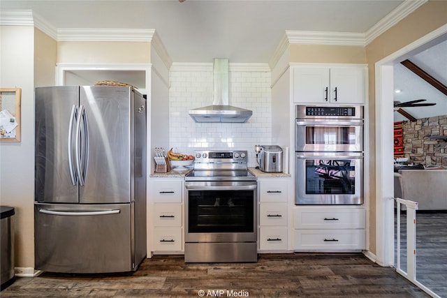 kitchen with white cabinetry, wall chimney exhaust hood, ceiling fan, dark hardwood / wood-style flooring, and appliances with stainless steel finishes