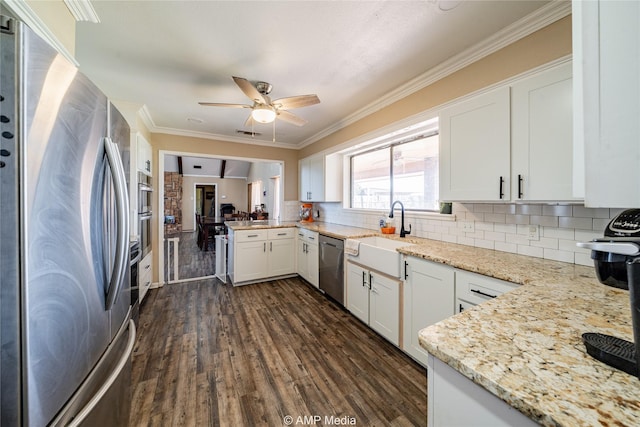 kitchen featuring light stone counters, stainless steel appliances, white cabinets, and sink