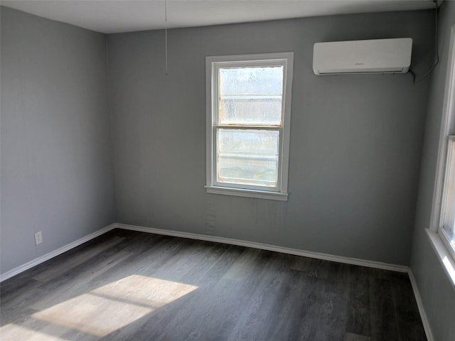 spare room featuring plenty of natural light, dark hardwood / wood-style flooring, and a wall unit AC