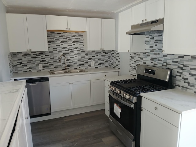 kitchen featuring sink, appliances with stainless steel finishes, dark hardwood / wood-style floors, white cabinets, and decorative backsplash