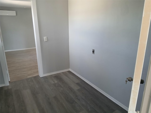 interior space with a wall unit AC and dark wood-type flooring